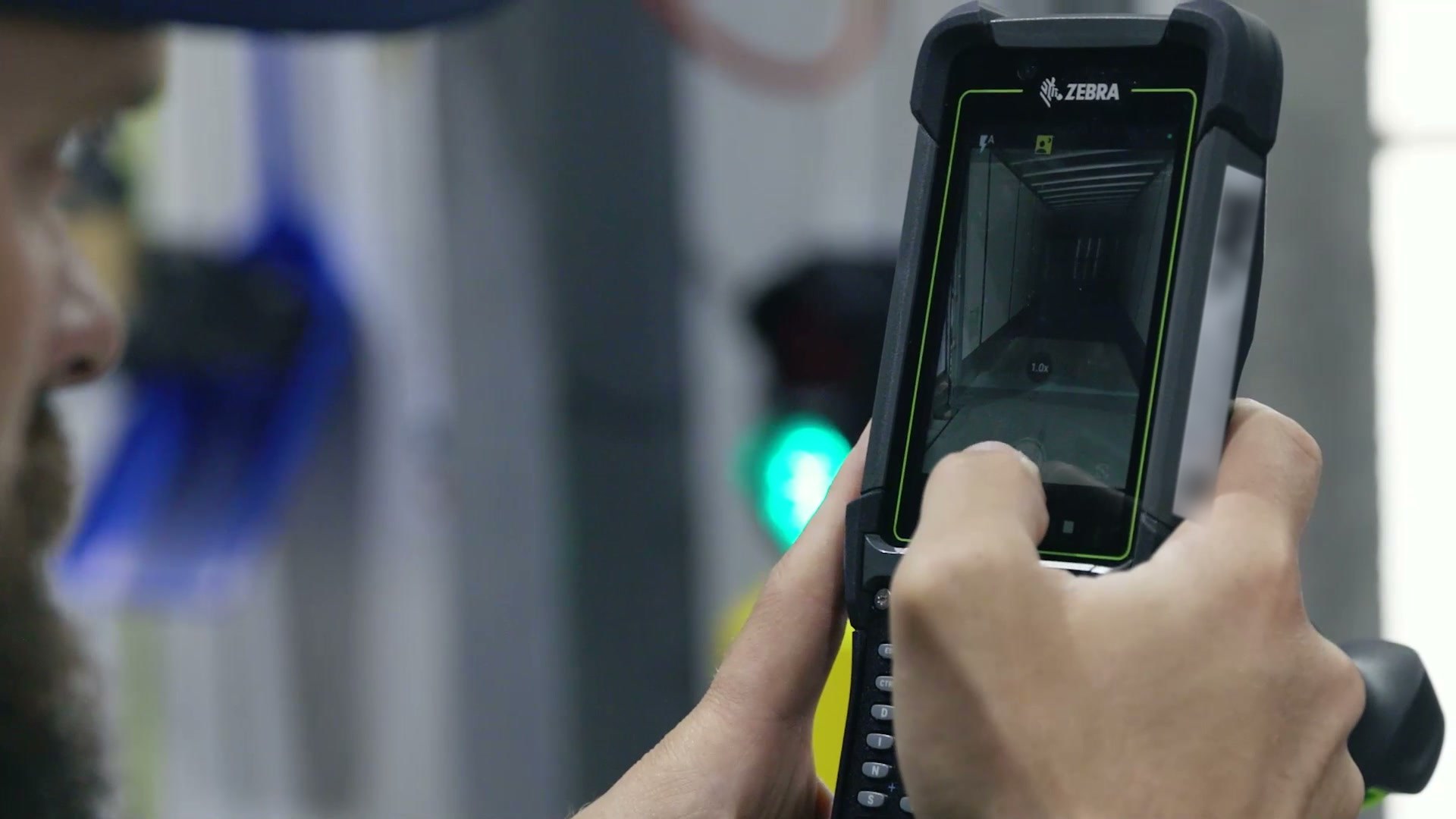 A dock operator photographing the inside of an empty trailer with the camera on a handheld terminal