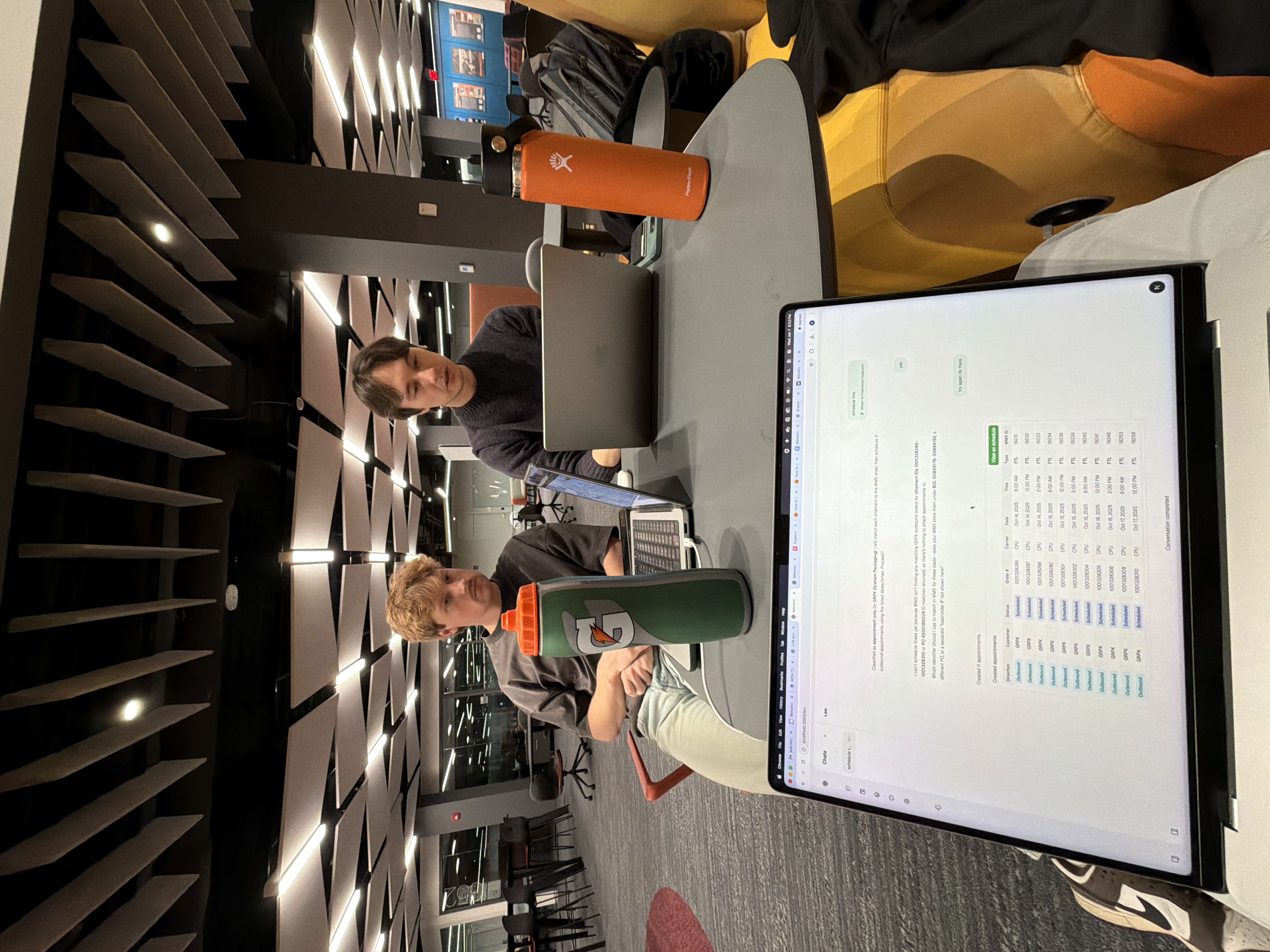 Two of the team reading through a scheduling run on a laptop