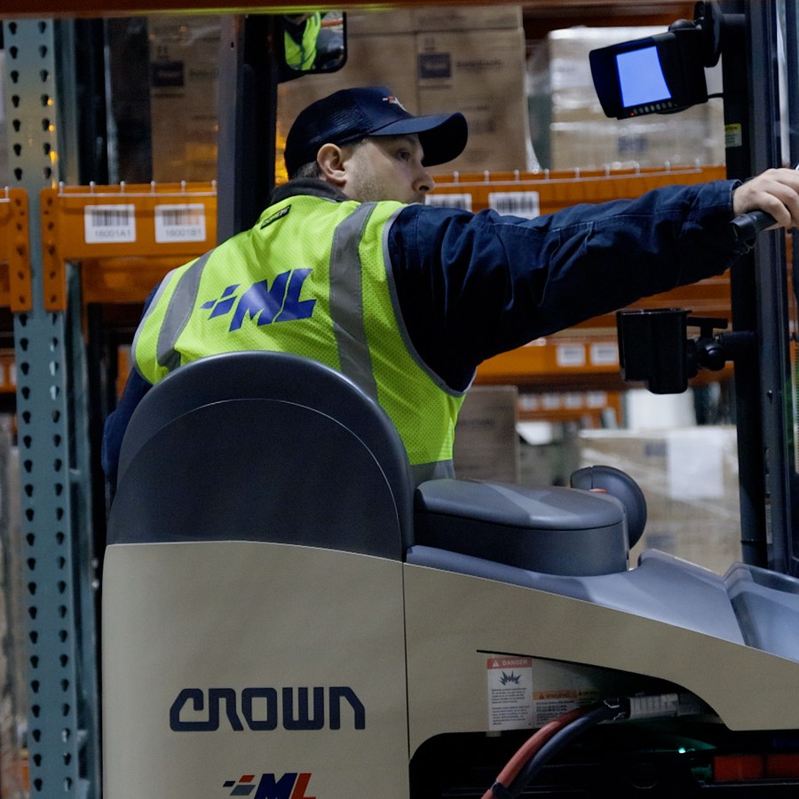 Derrick Guthrie in the cab of a reach truck at the Allenwood warehouse
