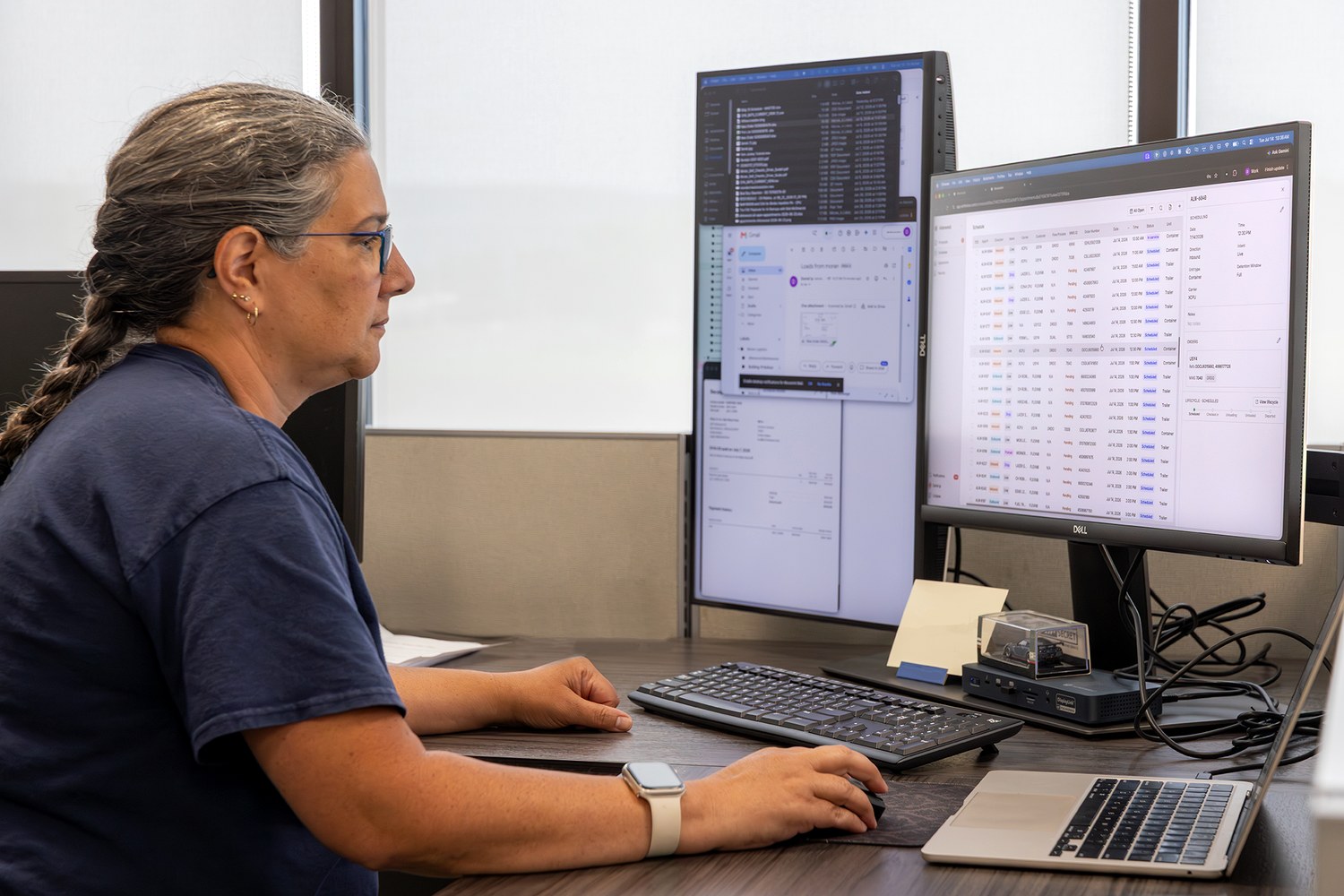 A customer service representative at a desk with the carrier’s email on one monitor and the Movo appointment board on the other