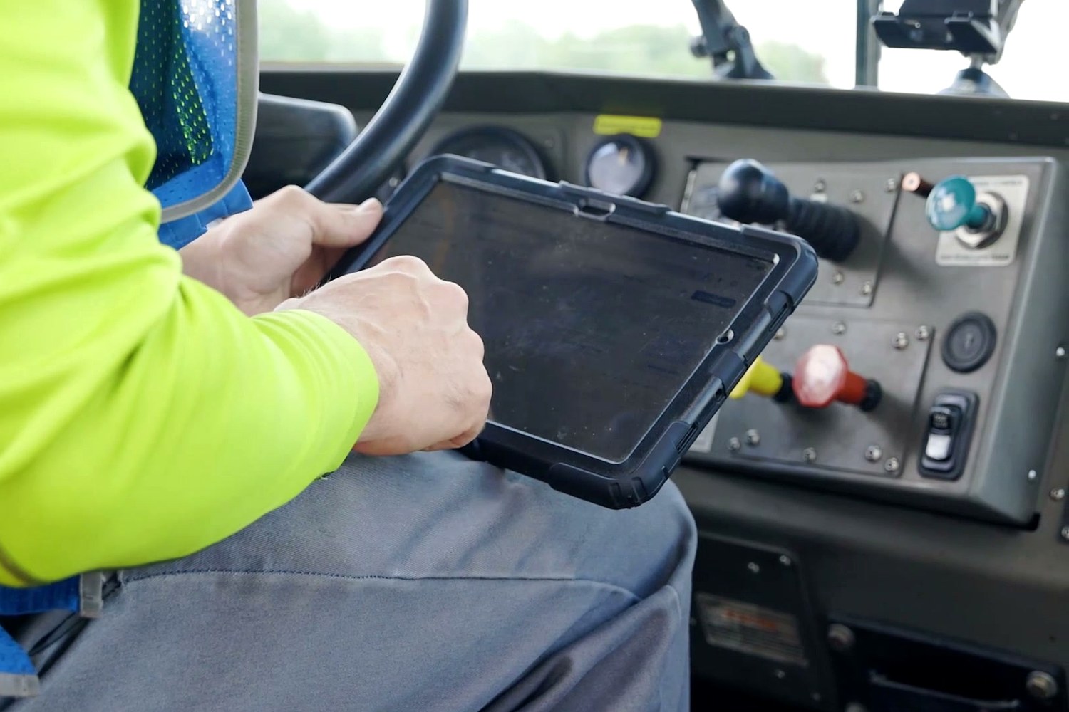 A yard jockey using a rugged tablet in the cab of a spotter truck