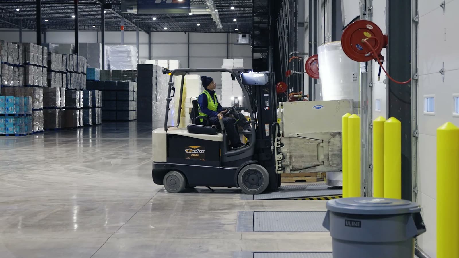 An operator driving a forklift on a warehouse floor