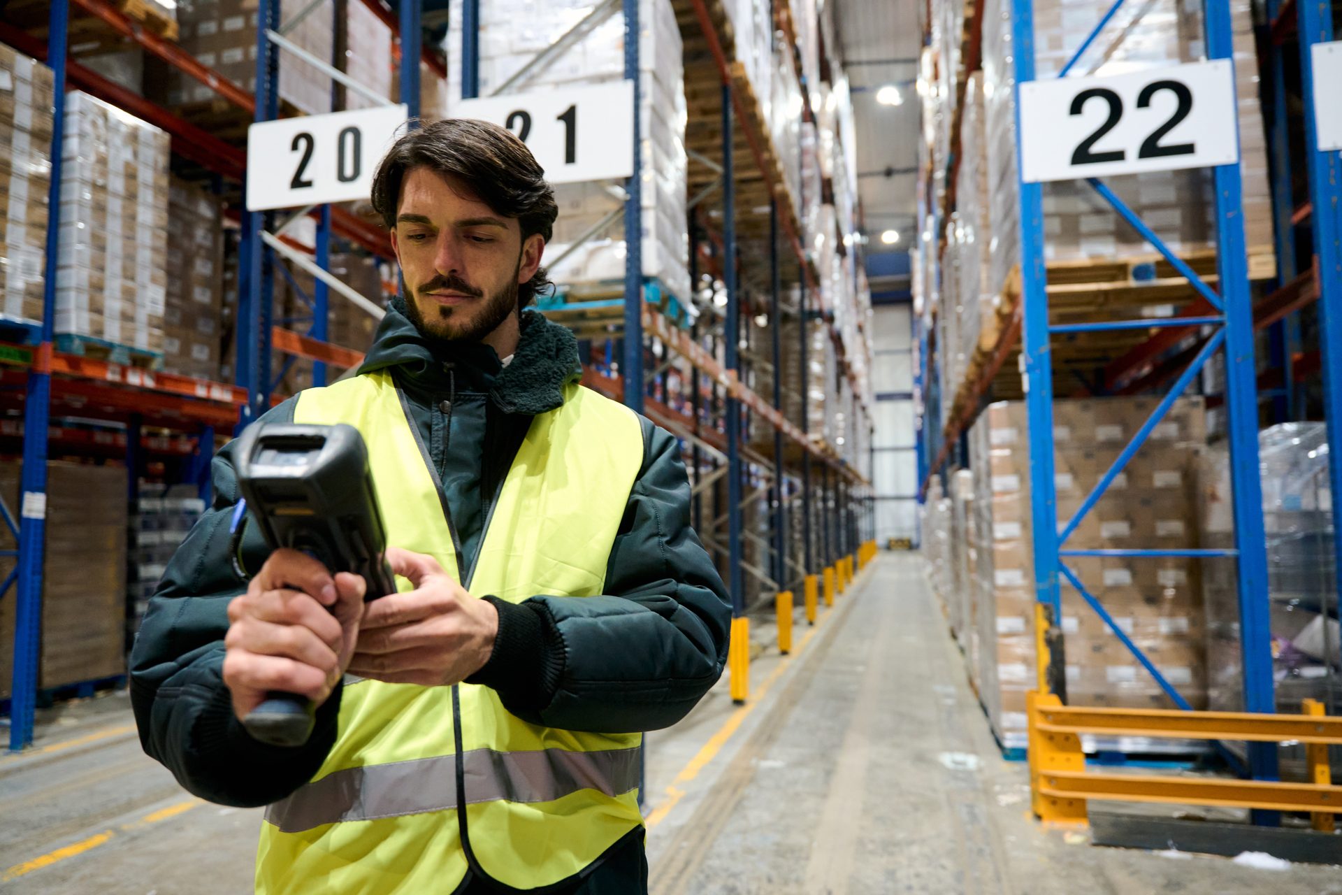 A dock operator holding a handheld scanner on the warehouse floor