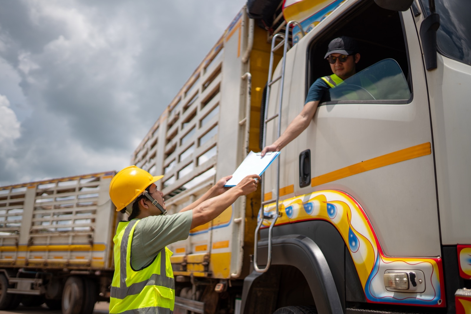 A truck driver confirming order paperwork during gate check-in