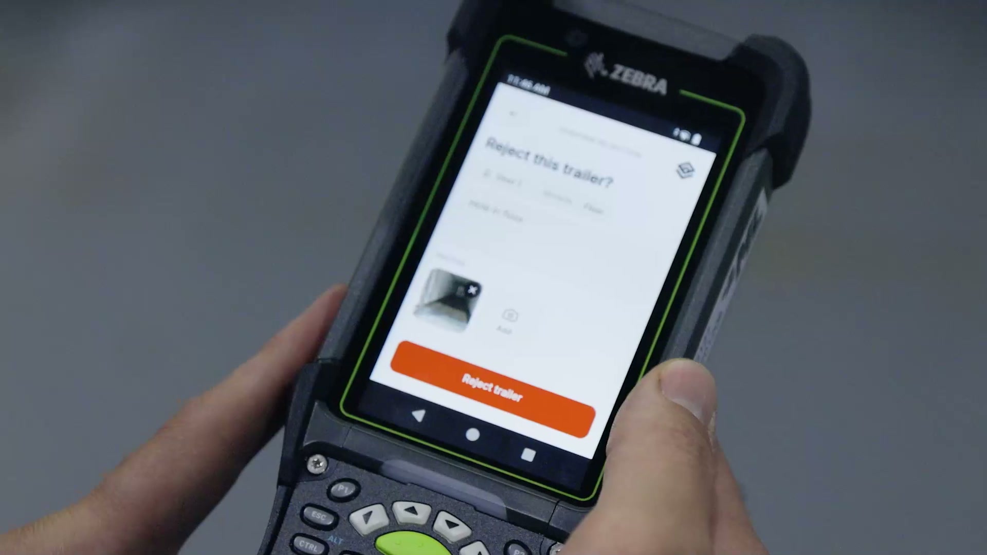 A dock operator confirming a trailer rejection on the RF handheld, with the reason, the operator note, and the attached photo on screen